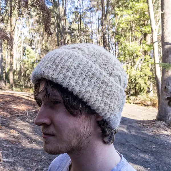Young man is wearing a white alpaca beanie