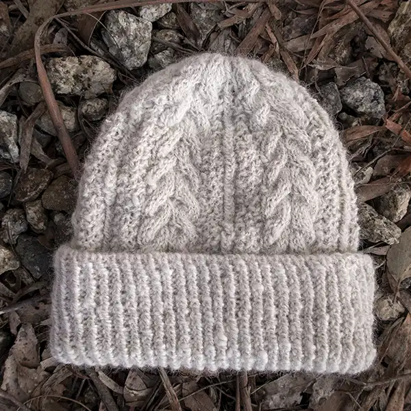White alpaca beanie showing the cable-knit-style
